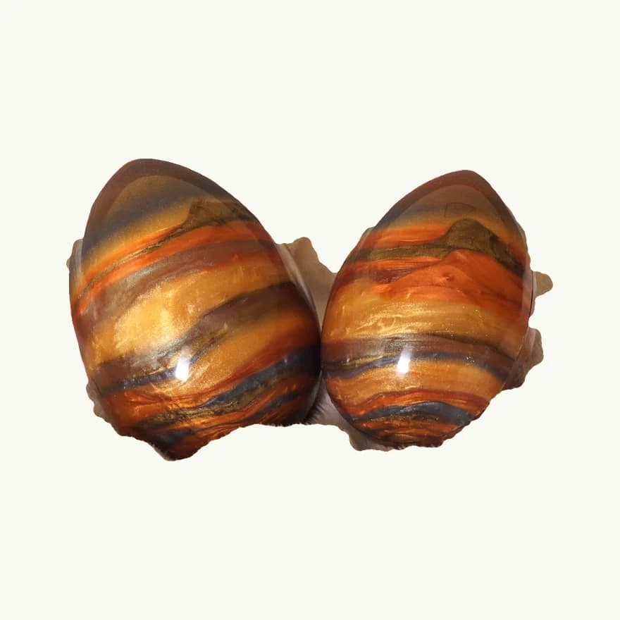 Zwei marmorierte Silikon-Eier, freigestellt auf heller Platte, echtes Betriebsfoto